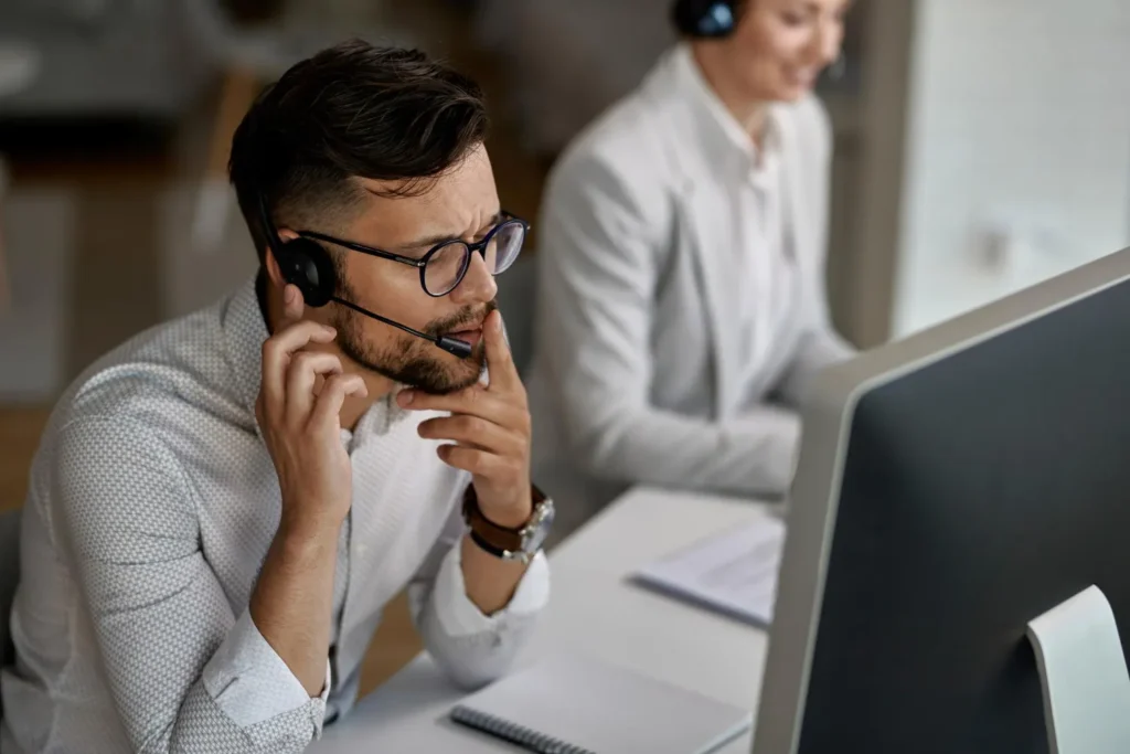 Agente de soporte con auriculares atendiendo una consulta de cliente de un proveedor IPTV